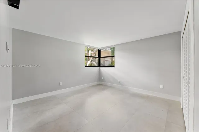 an empty room with windows and cabinet