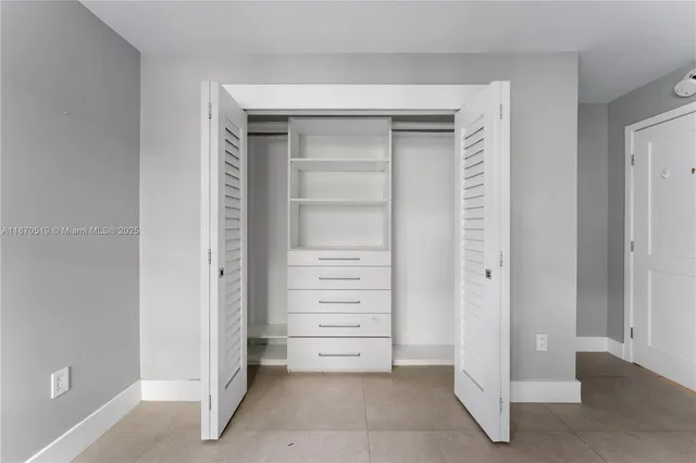 a view of walk in closet with empty racks