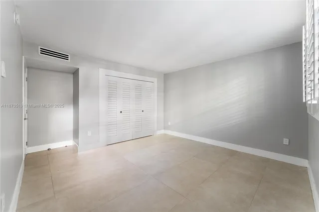 an empty room with windows and closet