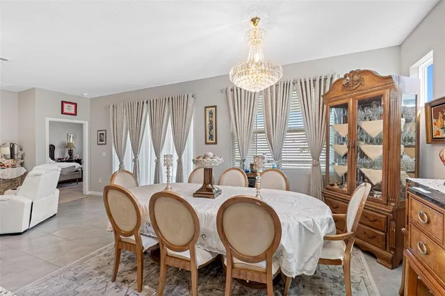 a dining room with furniture a chandelier and window