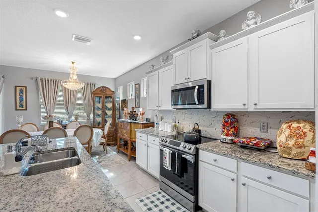 a kitchen that has a lot of cabinets a sink and appliances in it