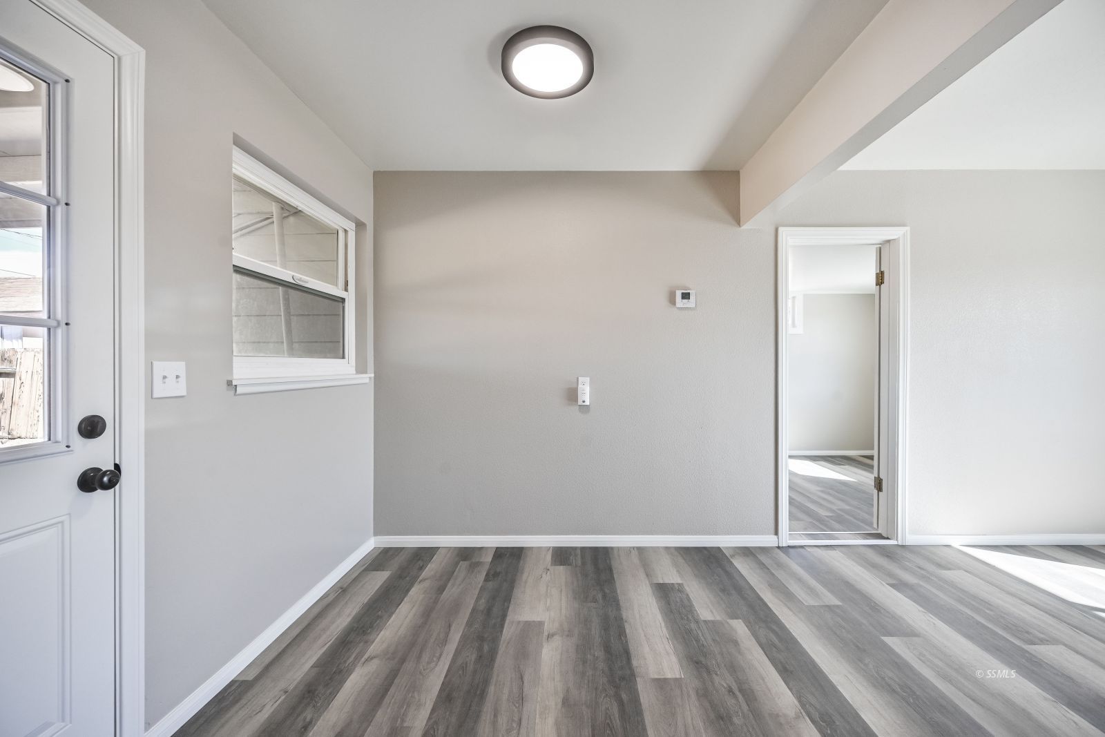 233 North Alvord Street Ridgecrest, CA 93555 - Photo 14 of 32 a view of an empty room with wooden floor and a window