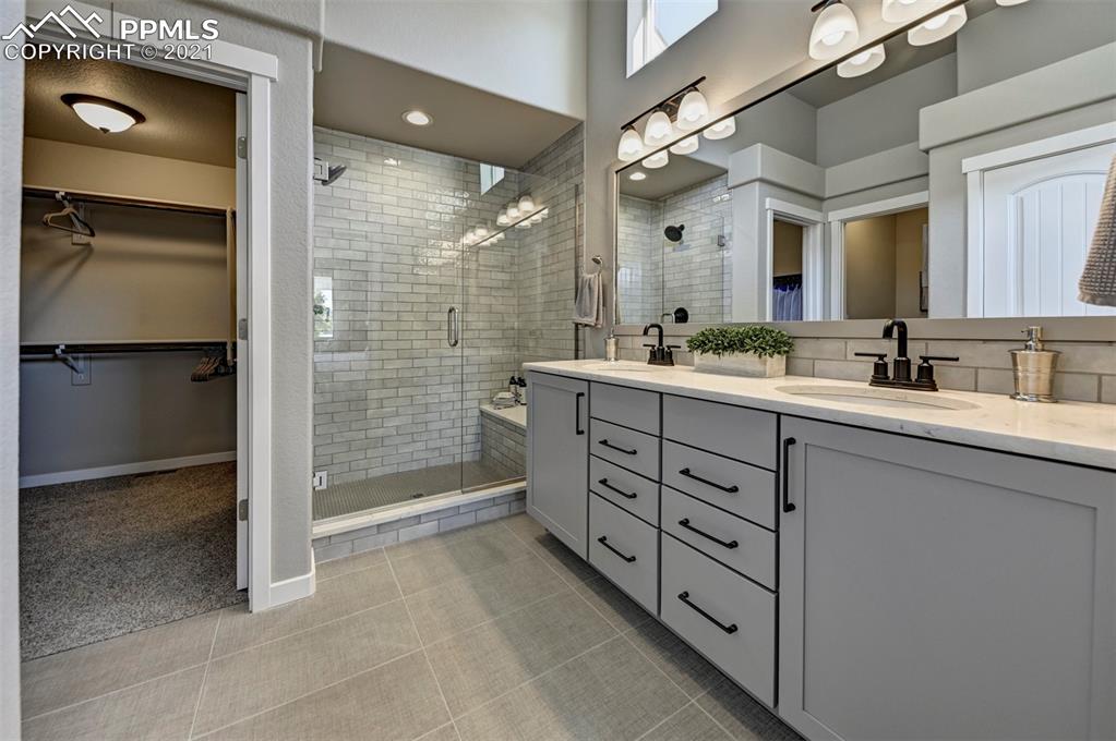 2903 Golden Meadow Way Colorado Springs, CO 80908 - Photo 22 of 49 a bathroom with a double vanity sink mirror and shower