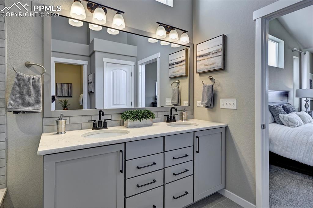 2903 Golden Meadow Way Colorado Springs, CO 80908 - Photo 23 of 49 a bathroom with a double vanity sink and a mirror