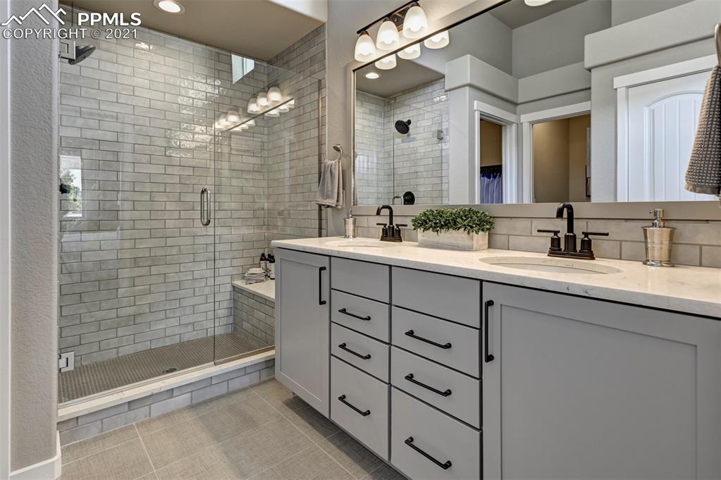 2903 Golden Meadow Way Colorado Springs, CO 80908 - Photo 25 of 49 a bathroom with a double vanity sink mirror and shower
