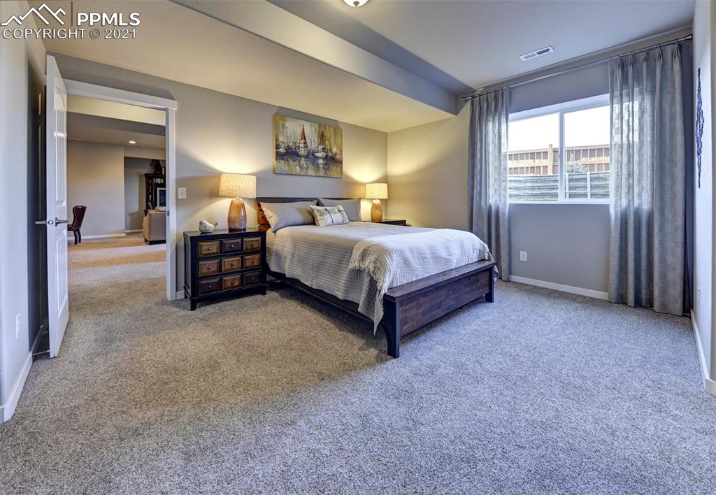 2903 Golden Meadow Way Colorado Springs, CO 80908 - Photo 34 of 49 a spacious bedroom with a bed and a lamp