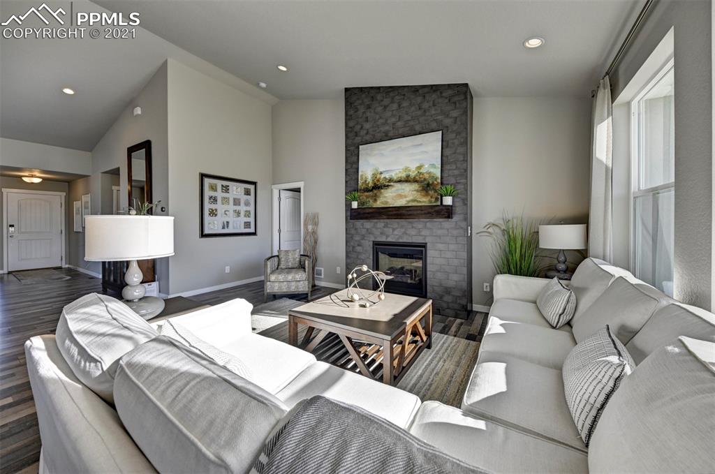 2903 Golden Meadow Way Colorado Springs, CO 80908 - Photo 10 of 49 a living room with furniture a flat screen tv and a fireplace