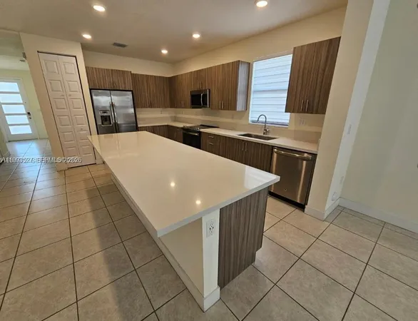 a kitchen with stainless steel appliances granite countertop a sink and a stove