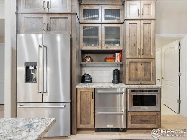 a kitchen with stainless steel appliances granite countertop a refrigerator and a sink