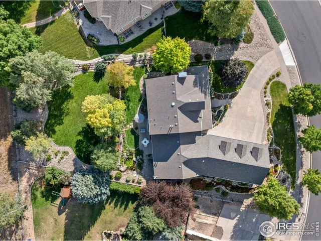 an aerial view of a house with a garden and lots of trees and houses