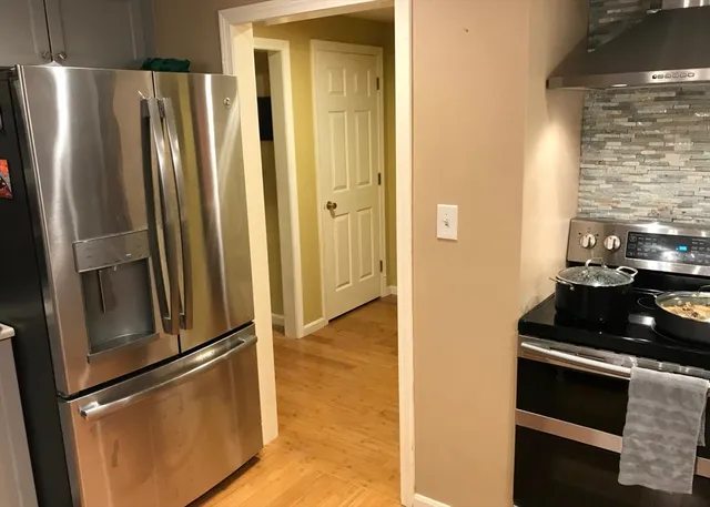 a metallic refrigerator freezer sitting in a kitchen