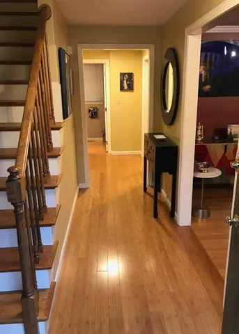 a view of a hallway with wooden floor and furniture