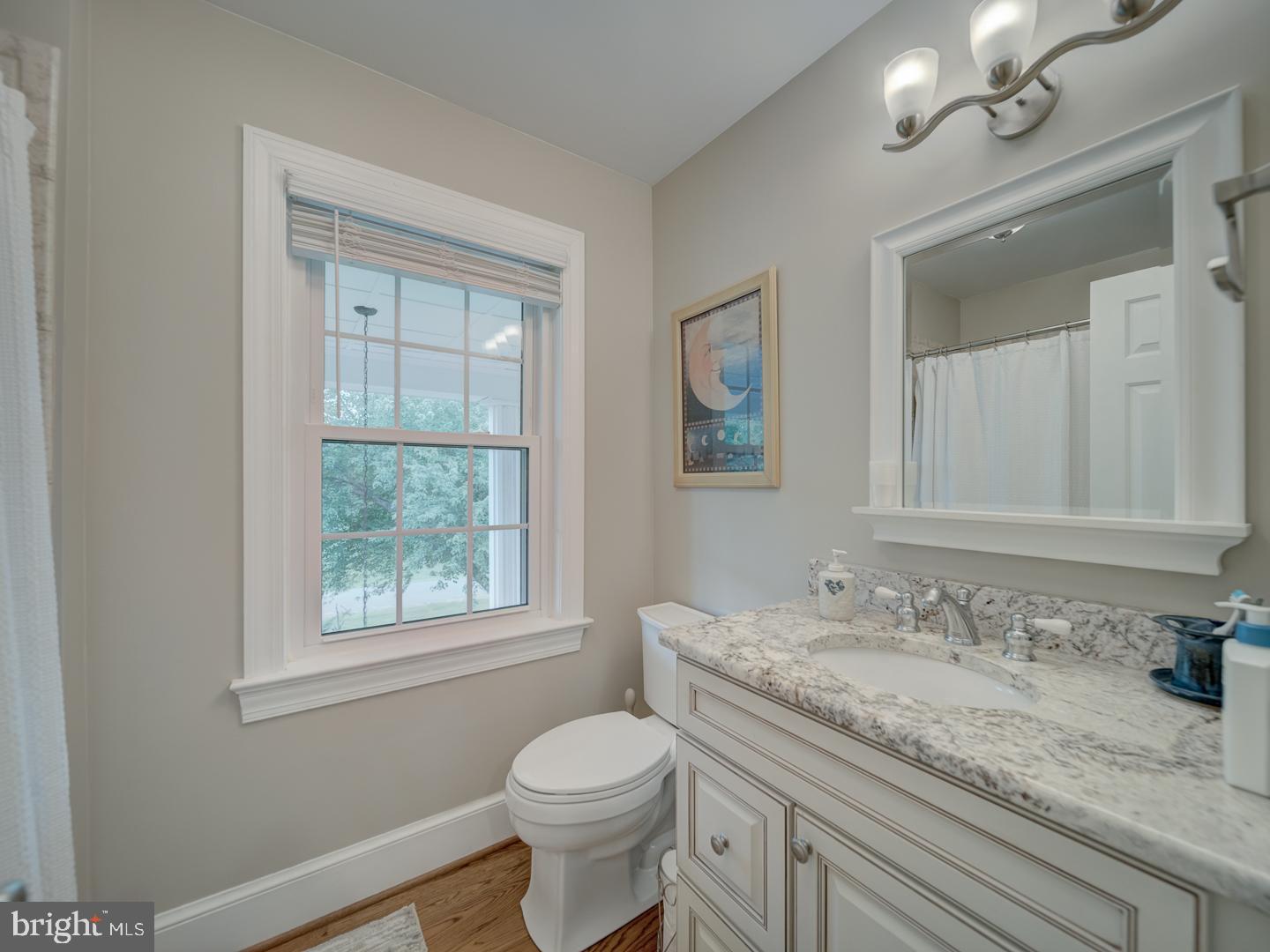 4387 Stepney Drive Gainesville, VA 20155 - Photo 52 of 74 a bathroom with a granite countertop sink a toilet and a window