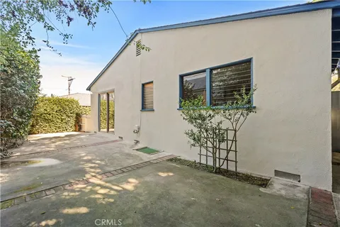 a view of a house with a yard and potted plants