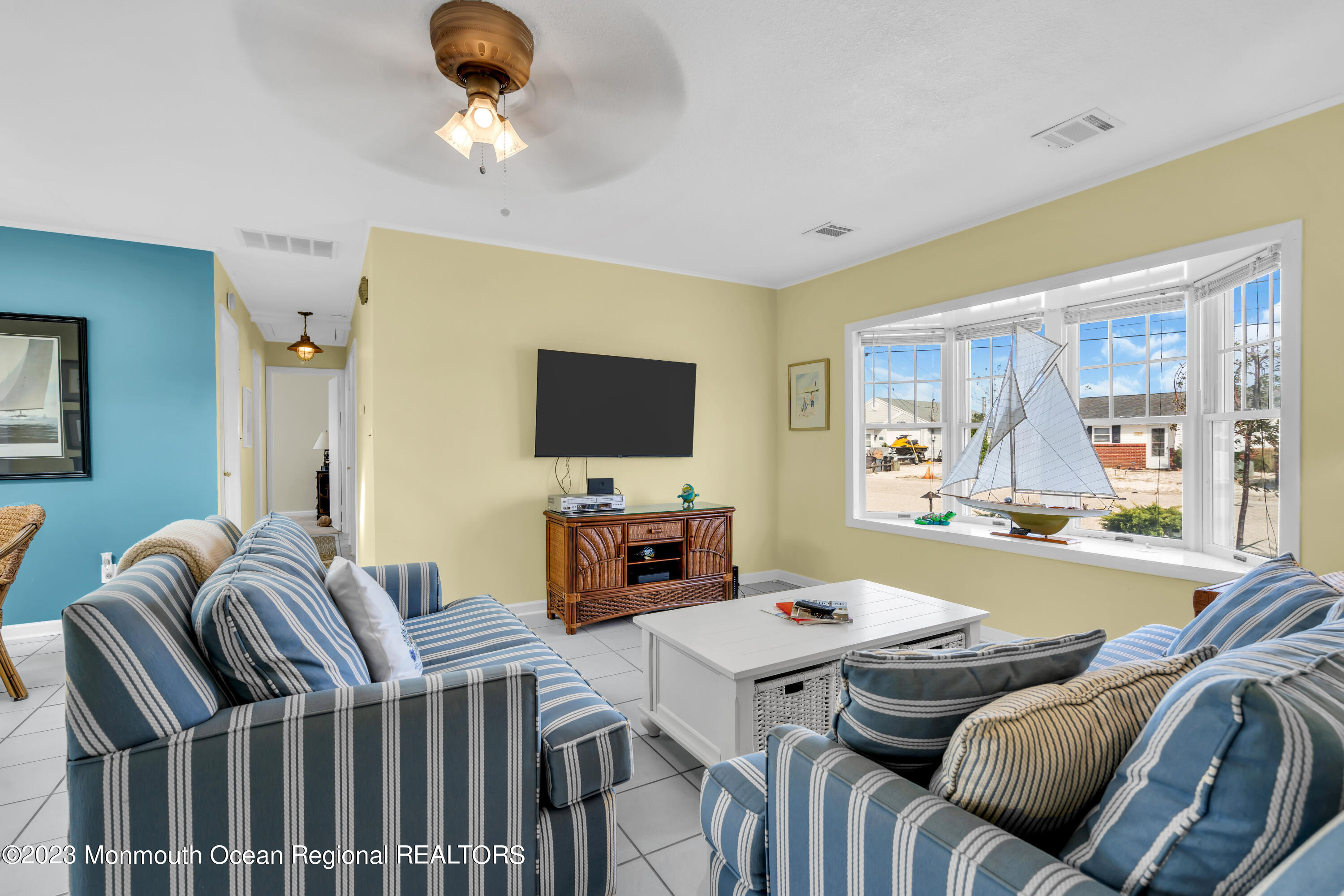 112 Newark Road Barnegat, NJ 08005 - Photo 9 of 44 a living room with furniture a flat screen tv and a chandelier