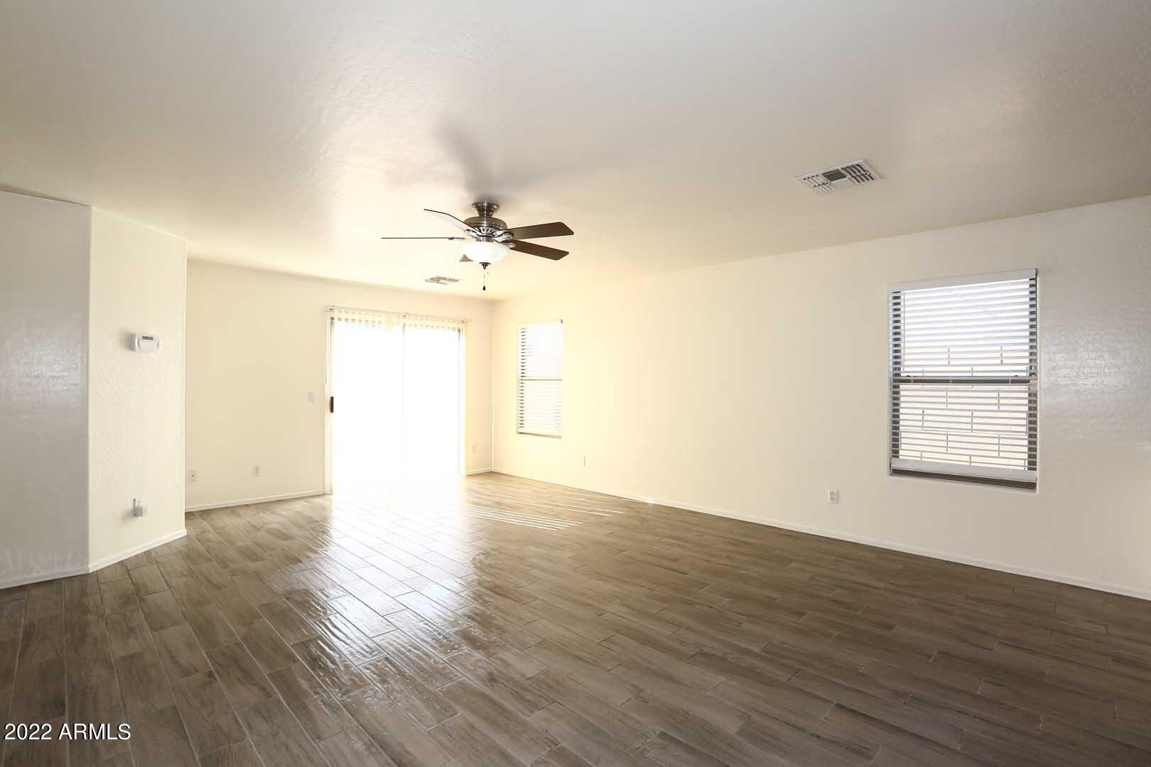 4319 West Carson Road Laveen, AZ 85339 - Photo 6 of 36 an empty room with wooden floor and windows