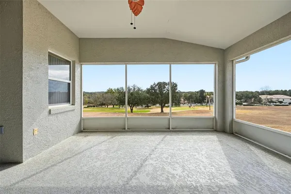 a view of an empty room with a floor to ceiling window and a ceiling fan