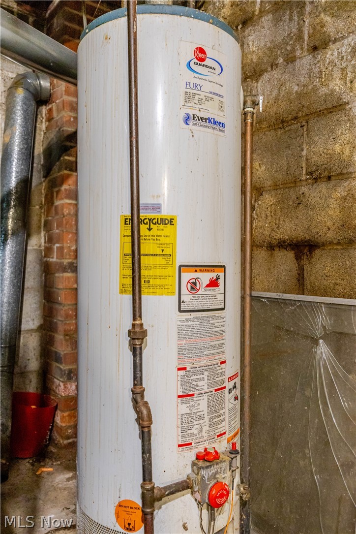 3825 Mayfield Road Cleveland Heights, OH 44121 - Photo 23 of 27 Water heater with visible plumbing lines, brick wall, concrete block wall, and metal ductwork