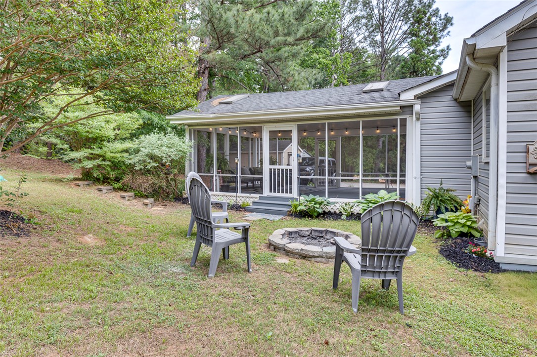 121 Crimson Leaf Lane Liberty, SC 29657 - Photo 30 of 30 This inviting backyard features a cozy fire pit and a charming screened porch, perfect for outdoor living.