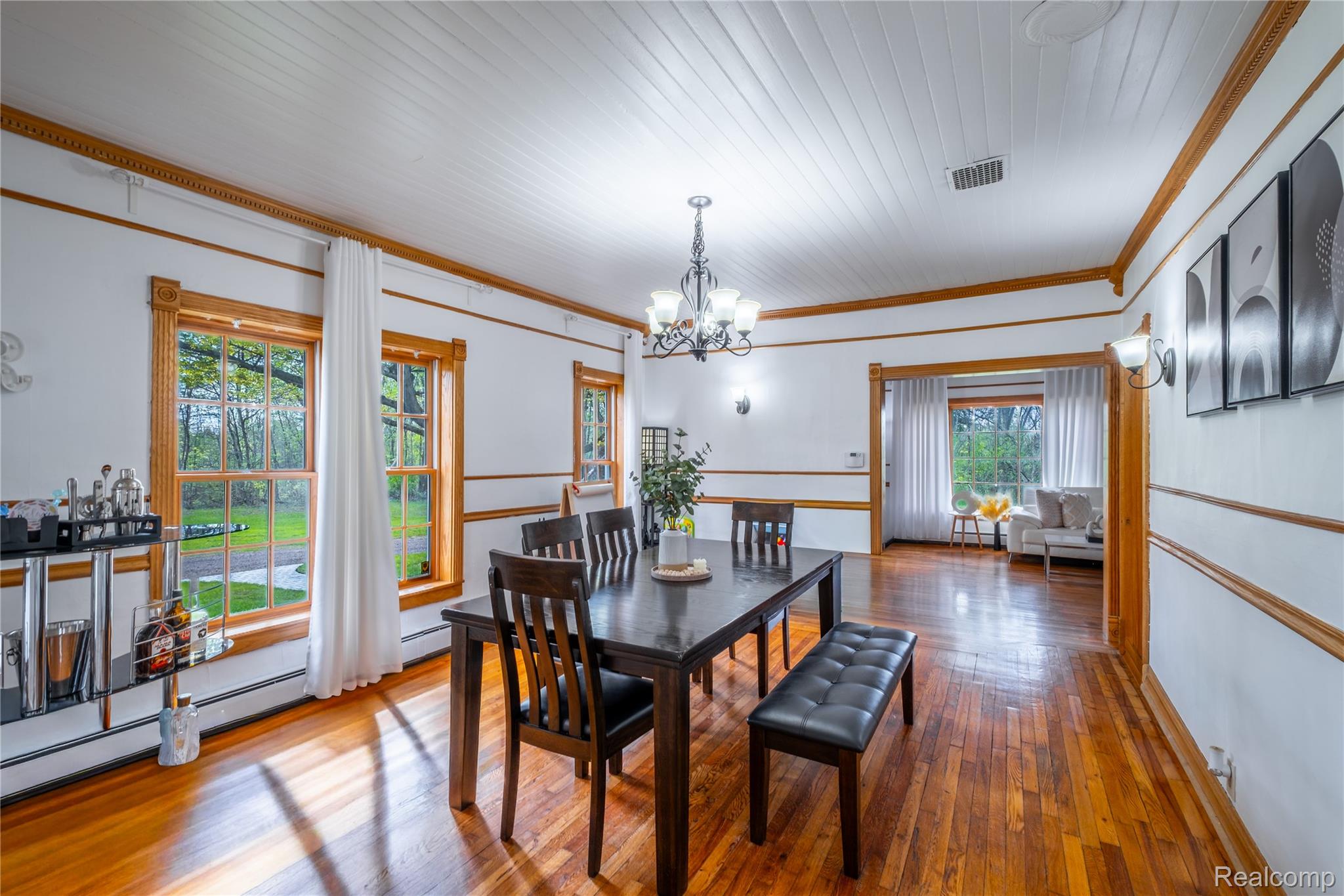 12164 Miller Road Lennon, MI 48449 - Photo 19 of 35 Dining space featuring wood-type flooring, hanging lights, crown molding, and a baseboard radiator