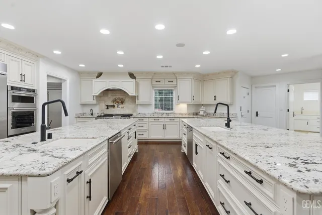 a large kitchen with stainless steel appliances granite countertop a stove and a sink
