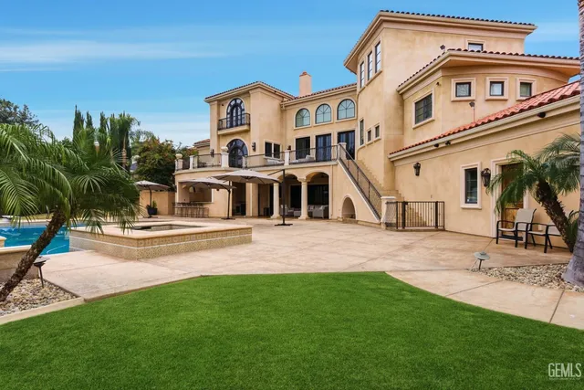 an aerial view of a house with swimming pool and mountains
