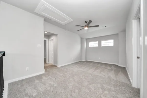 an empty room with fan and windows