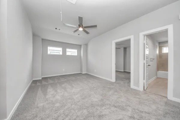 an empty room with windows and fan
