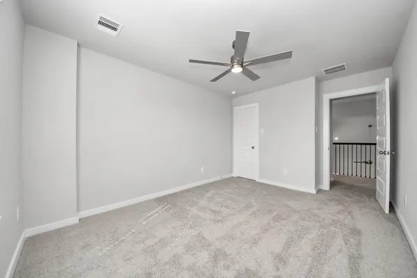 an empty room with a window and a ceiling fan