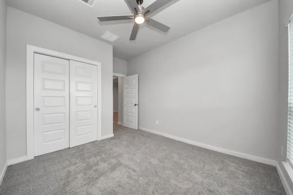 a bedroom with a large bed chandelier and a window