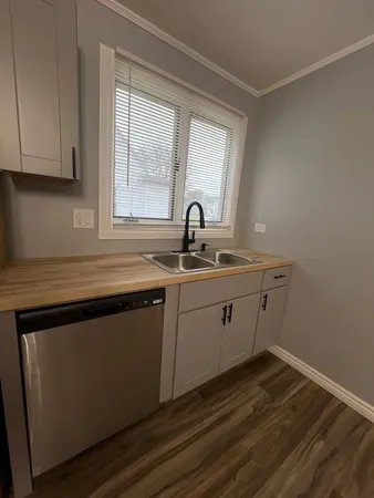 a kitchen with a sink cabinets and wooden floor