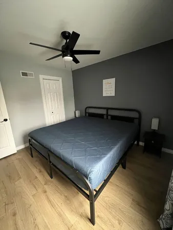 a bed sitting in a bedroom next to a lamp