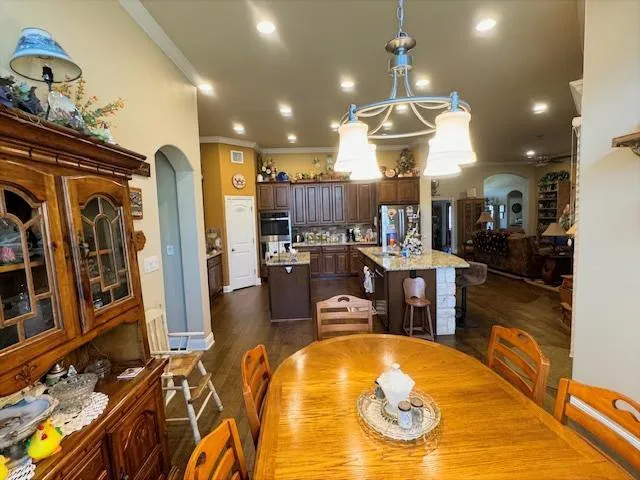 a room with stainless steel appliances lots of furniture and kitchen view