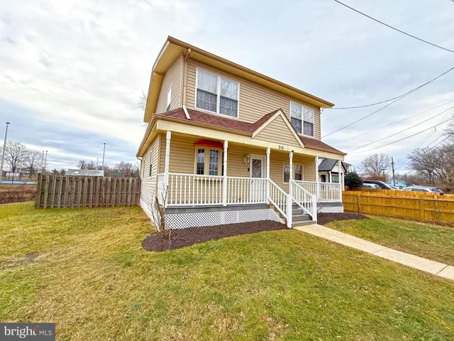 a view of a house with a yard and sitting area