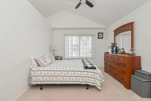 a bedroom with a bed a window and dresser