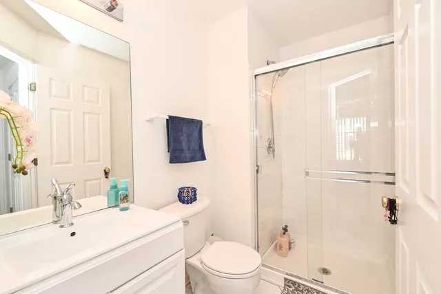 a bathroom with a sink a mirror a toilet and shower