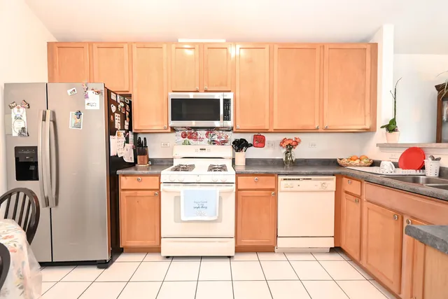 a kitchen with stainless steel appliances a refrigerator sink and microwave