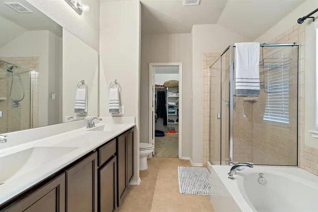 a bathroom with a granite countertop sink mirror and a bathtub
