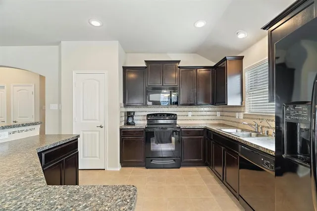 a kitchen with stainless steel appliances granite countertop a stove refrigerator and cabinets
