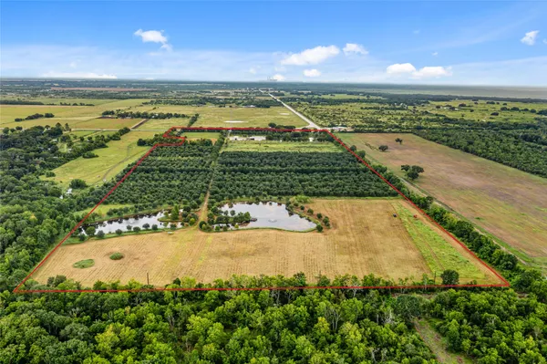 an aerial view of ocean and residential houses with outdoor space