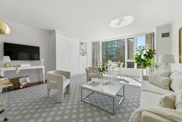 a living room with furniture a flat screen tv and a large window