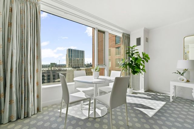 a dining room with furniture potted plants and wooden floor