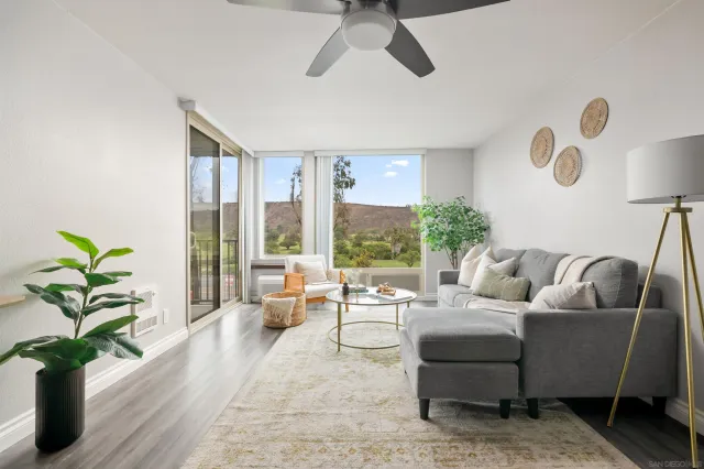 a living room with furniture potted plant and a large window