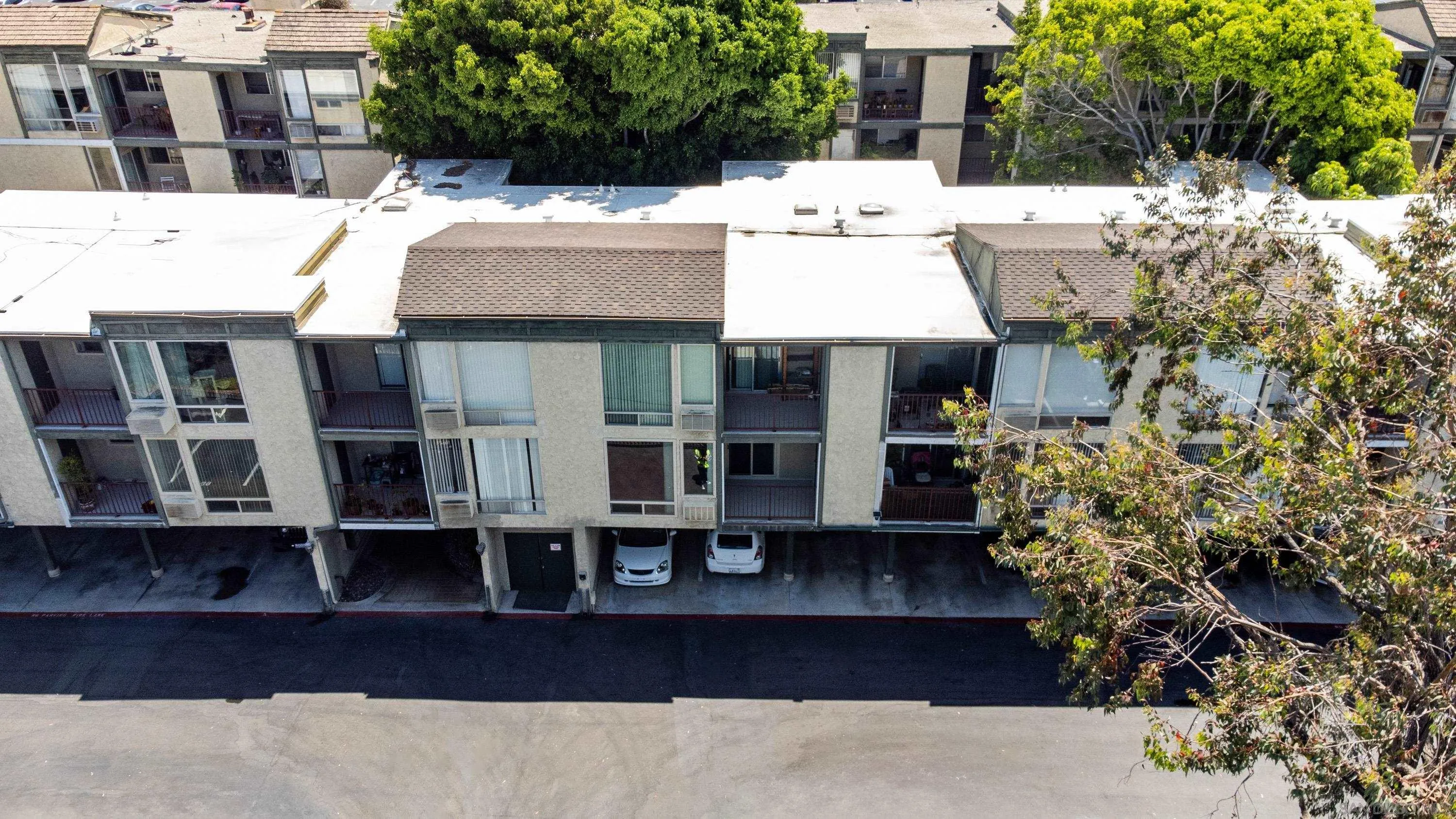 6675 Mission Gorge Road, Unit B104 San Diego, CA 92120 - Photo 13 of 14 a view of a white building next to a yard