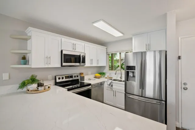 a kitchen with stainless steel appliances a refrigerator stove microwave and sink