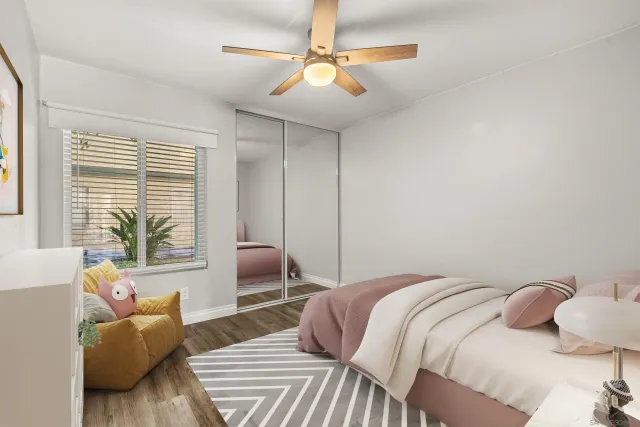 a bedroom with a bed couch and a large window