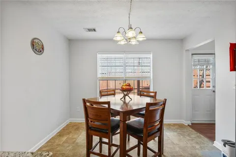 a view of a dining room with furniture a chandelier and wooden floor