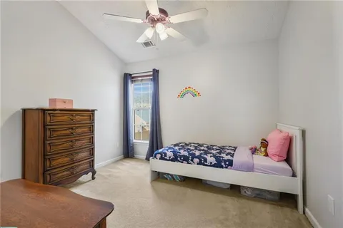 a bedroom with a bed and a chandelier fan