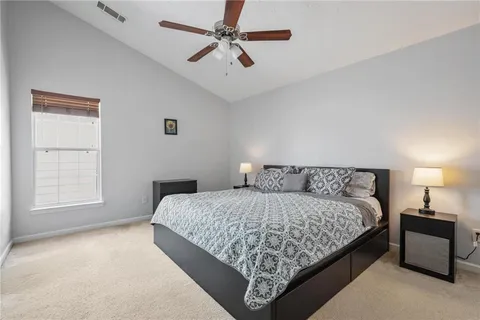 a bedroom with a bed chandelier and a window