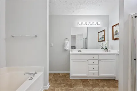 a bathroom with a tub sink and mirror